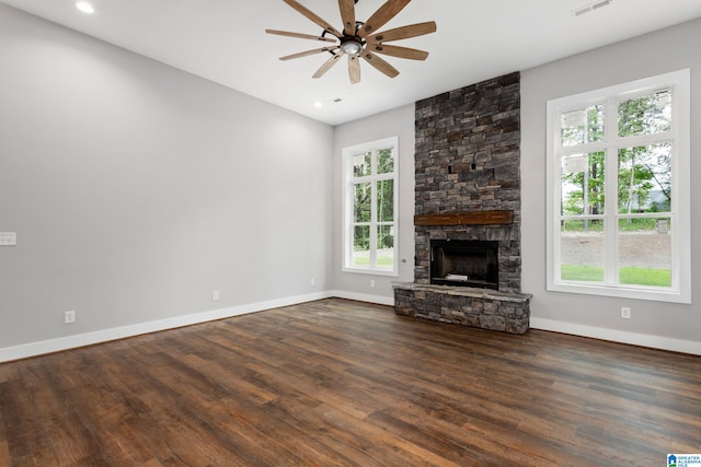 unfurnished living room with a ceiling fan, a fireplace, dark wood finished floors, and baseboards