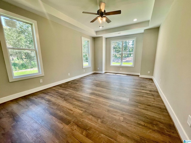 unfurnished room with ceiling fan, dark hardwood / wood-style flooring, and a healthy amount of sunlight