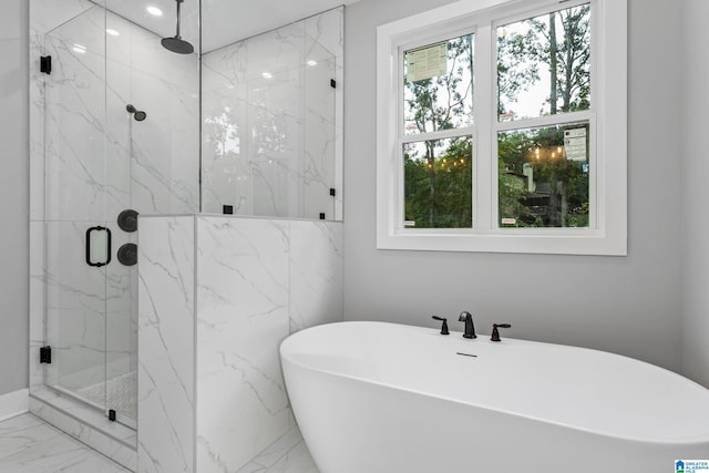 full bath with marble finish floor, a marble finish shower, and a freestanding tub