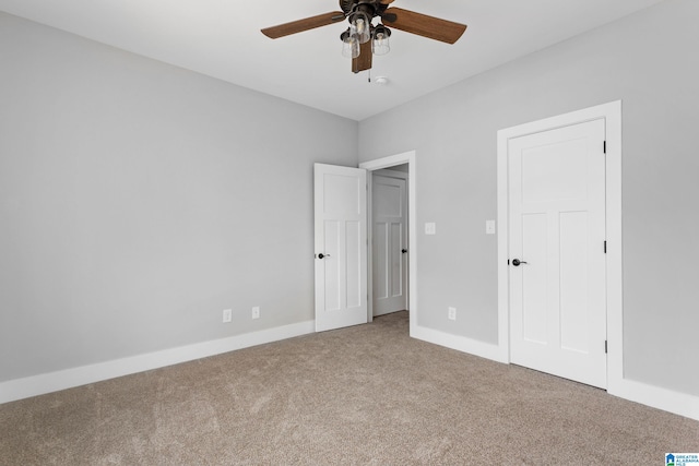 unfurnished bedroom with ceiling fan, carpet floors, and baseboards