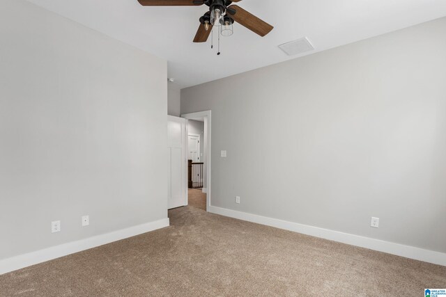 carpeted spare room with ceiling fan