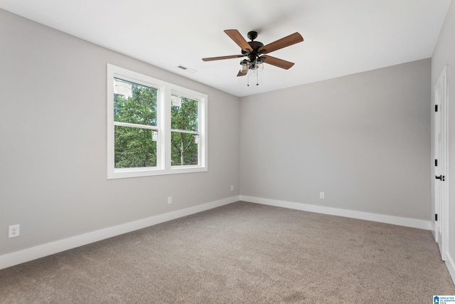 empty room with baseboards, visible vents, ceiling fan, and carpet flooring