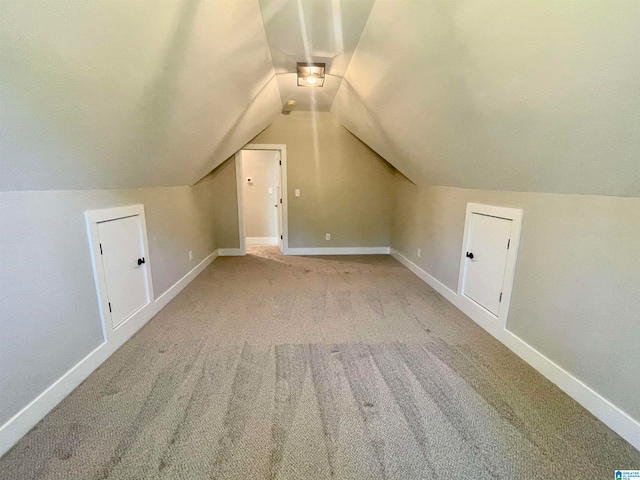 bonus room featuring light carpet and vaulted ceiling