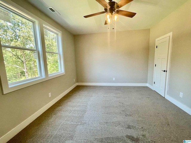 spare room featuring ceiling fan and carpet