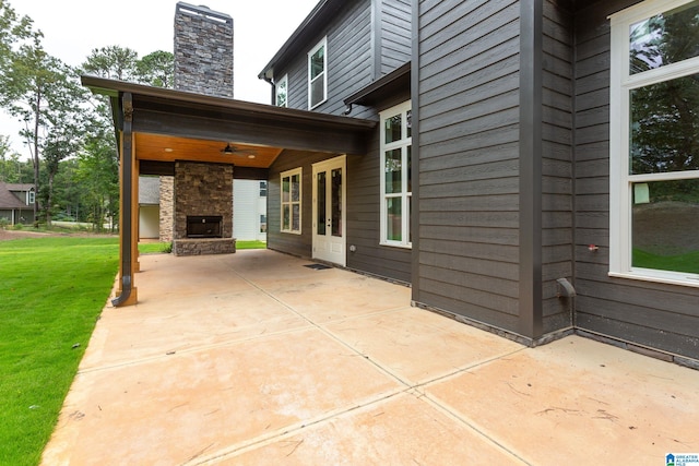 view of patio / terrace with an outdoor stone fireplace and a ceiling fan