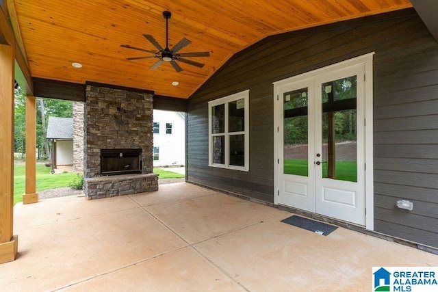 view of patio / terrace with an outdoor stone fireplace, ceiling fan, and french doors