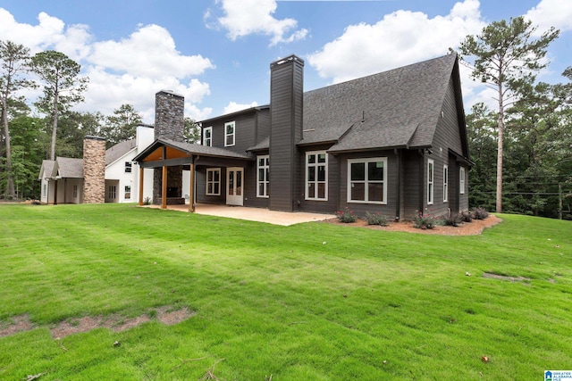 rear view of house with a lawn and a patio area