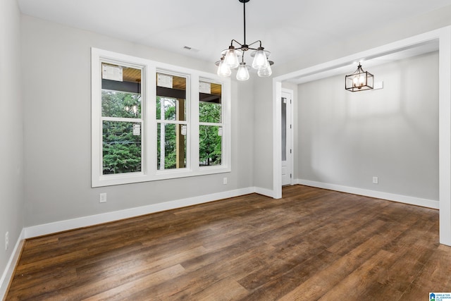 interior space with baseboards, a chandelier, and dark wood-type flooring