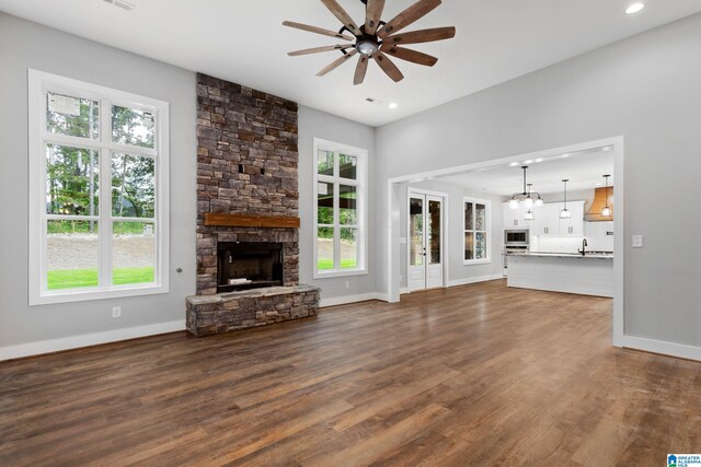 kitchen featuring white cabinets, a kitchen island with sink, premium range hood, and light stone countertops