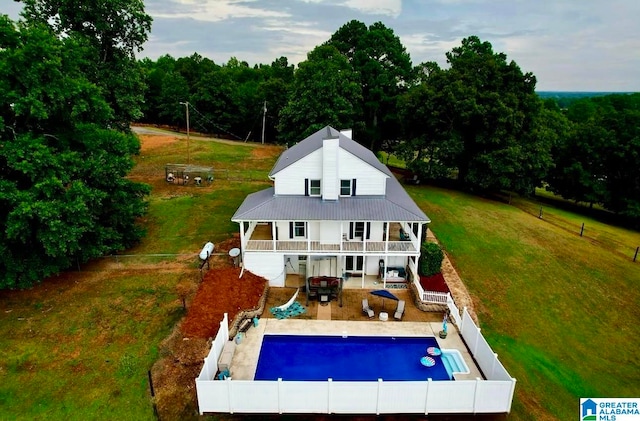 rear view of property with outdoor lounge area, a balcony, a fenced in pool, and a patio