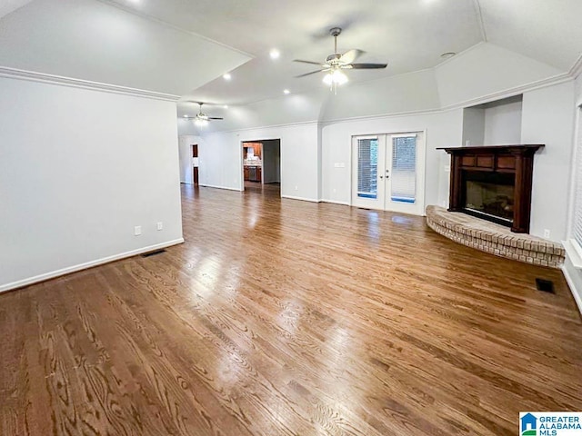 unfurnished living room featuring lofted ceiling, french doors, a fireplace, and ceiling fan