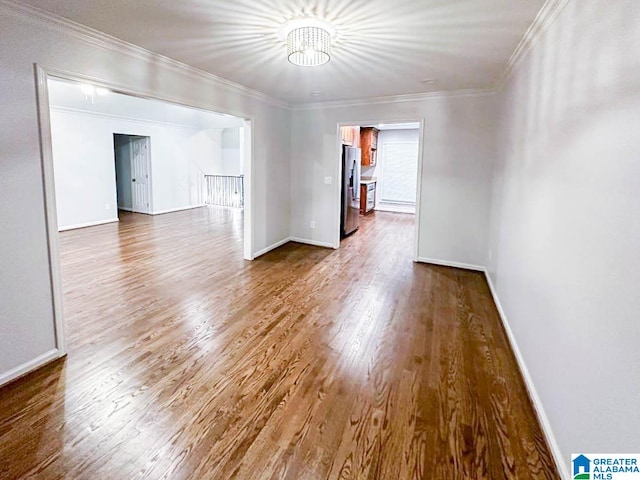 spare room with hardwood / wood-style flooring and crown molding