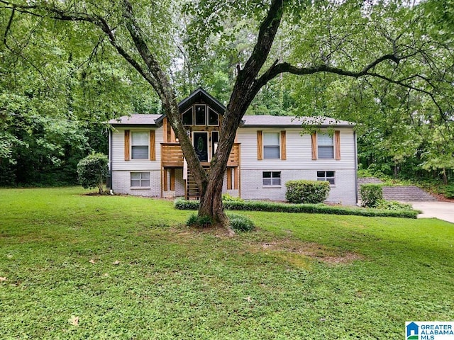 split foyer home featuring a front yard and brick siding