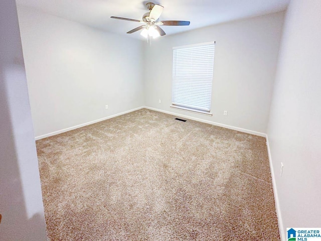 carpeted empty room featuring ceiling fan, visible vents, and baseboards