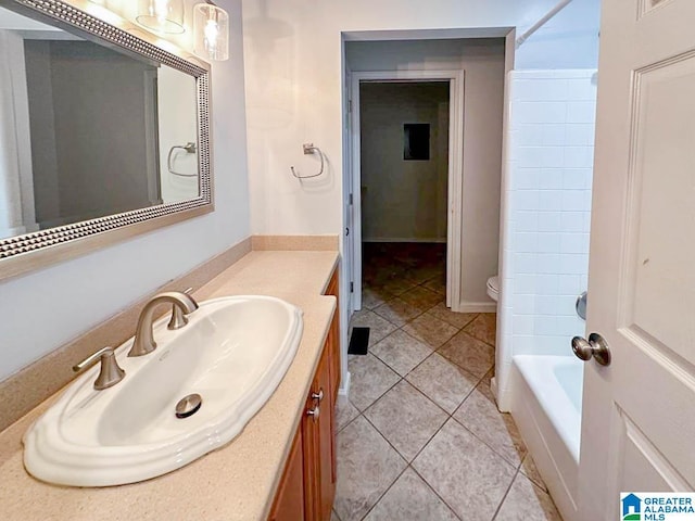 bathroom featuring tile patterned flooring, vanity, toilet, and a bathing tub