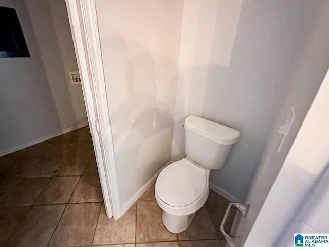 bathroom featuring toilet, baseboards, and tile patterned floors