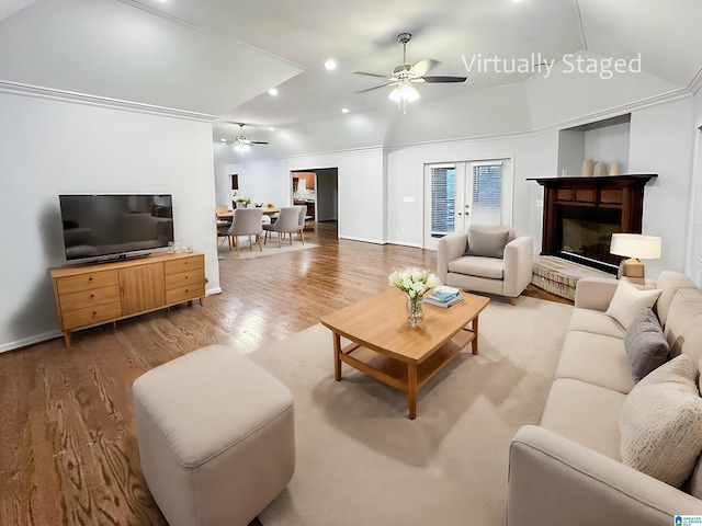 living area with baseboards, a ceiling fan, a glass covered fireplace, wood finished floors, and recessed lighting