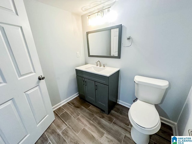 bathroom featuring wood tiled floor, baseboards, vanity, and toilet