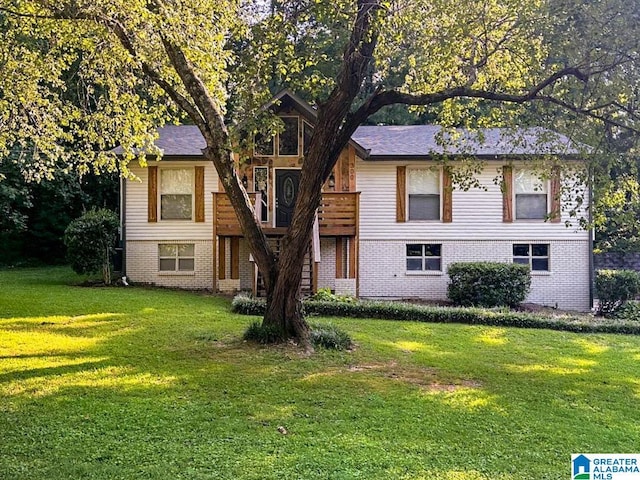 view of front of house featuring brick siding and a front yard