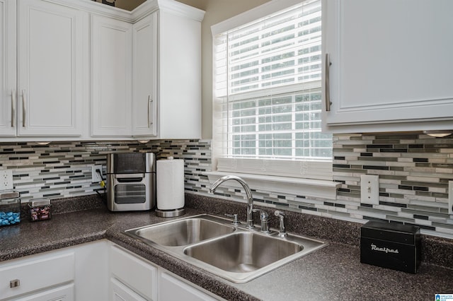 kitchen featuring white cabinets, sink, and tasteful backsplash