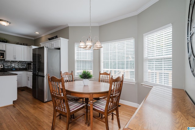 dining space featuring light wood-type flooring, baseboards, an inviting chandelier, recessed lighting, and ornamental molding