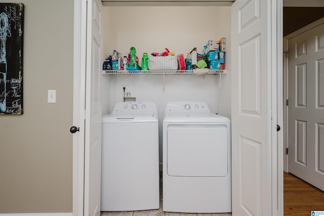laundry area featuring washing machine and dryer, light wood-type flooring, and laundry area