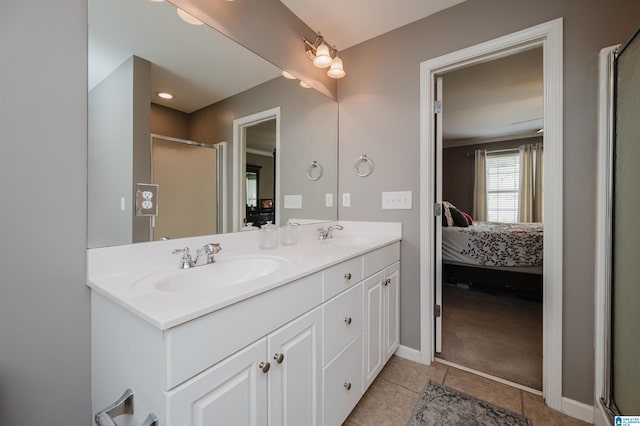 ensuite bathroom with a shower stall, tile patterned floors, a sink, double vanity, and ensuite bath