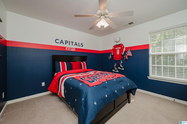 carpeted bedroom featuring baseboards, a ceiling fan, and visible vents