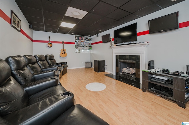 living room with a fireplace, wood-type flooring, and a drop ceiling