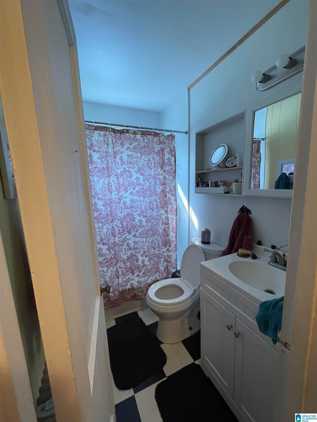 bathroom with toilet, vanity, and curtained shower