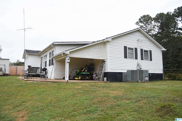 back of house featuring cooling unit, a lawn, and a patio