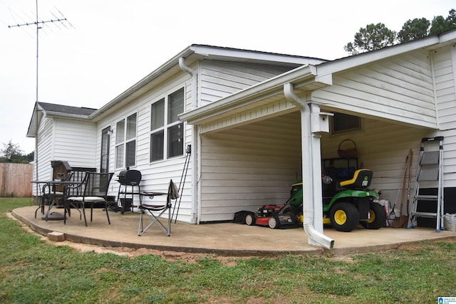 back of house featuring a lawn and a patio area