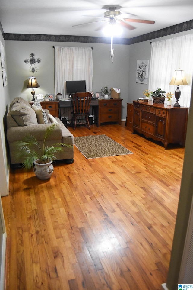 living room featuring hardwood / wood-style floors and ceiling fan