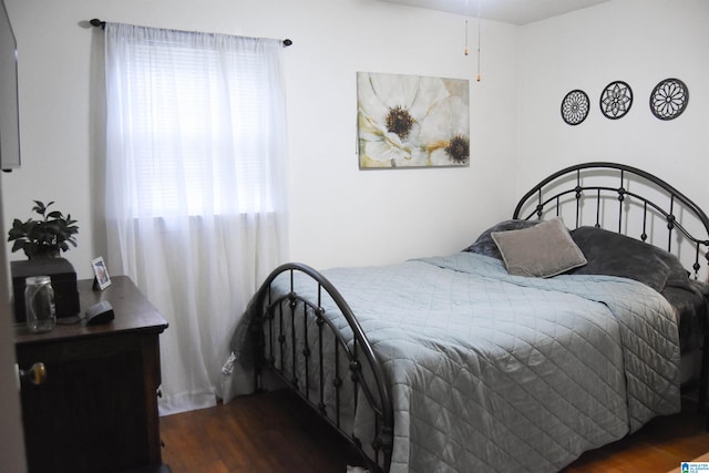 bedroom with dark wood-type flooring and multiple windows