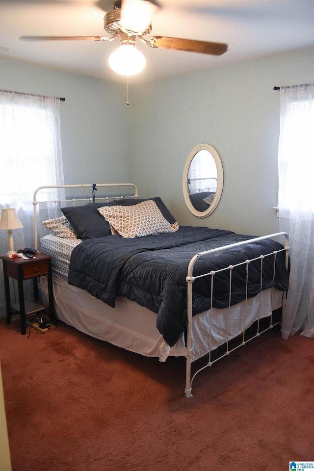 bedroom featuring multiple windows, ceiling fan, and carpet floors