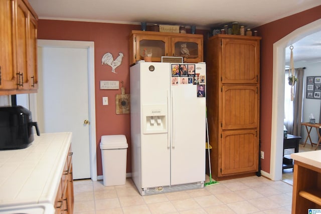 kitchen with tile counters and white fridge with ice dispenser