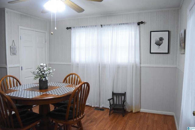 dining space with crown molding, ceiling fan, and hardwood / wood-style flooring