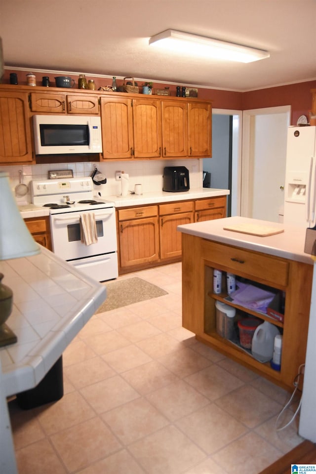 kitchen featuring tile countertops, white appliances, and light tile patterned flooring