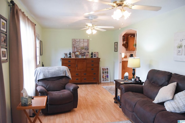 living room with a wealth of natural light, light hardwood / wood-style flooring, and ceiling fan