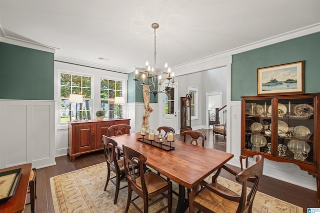 dining room featuring dark hardwood / wood-style flooring, a notable chandelier, and crown molding