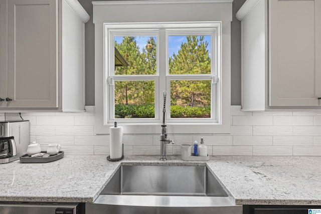 kitchen featuring gray cabinetry, backsplash, and sink