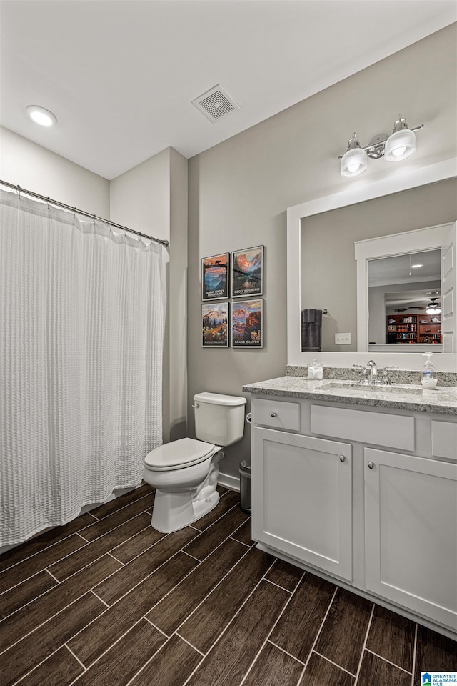 bathroom featuring wood-type flooring, toilet, and vanity