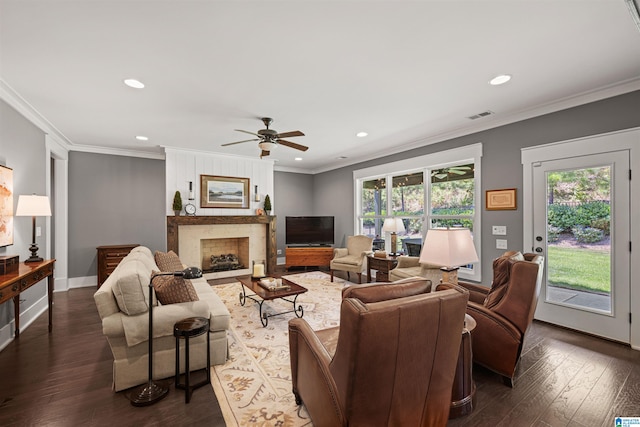 living room featuring dark wood-type flooring, a healthy amount of sunlight, ceiling fan, and a high end fireplace