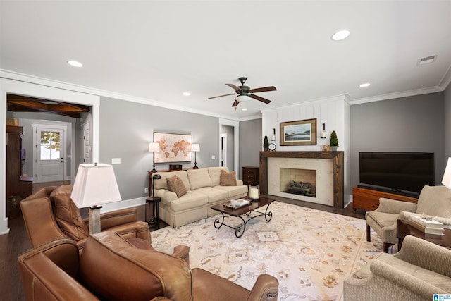 living room featuring crown molding, a fireplace, hardwood / wood-style flooring, and ceiling fan