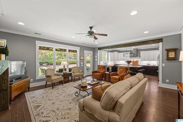 living room with dark wood-type flooring, ceiling fan, and crown molding