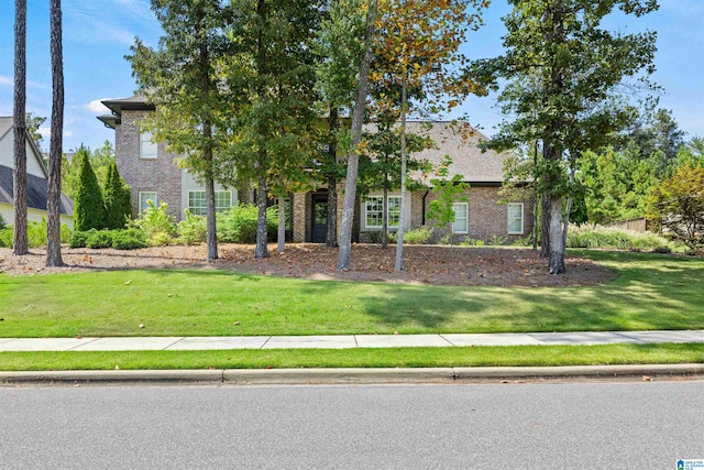 obstructed view of property with a front lawn