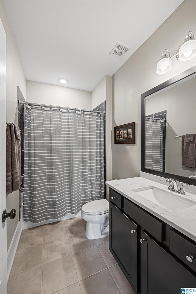 bathroom with tile patterned flooring, vanity, and toilet