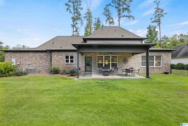 rear view of house with a patio, a yard, and cooling unit