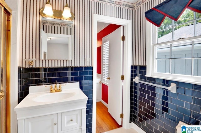 bathroom featuring plenty of natural light, vanity, tile walls, and hardwood / wood-style flooring