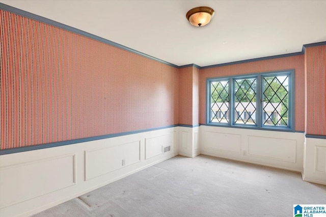 unfurnished room featuring ornamental molding and carpet floors